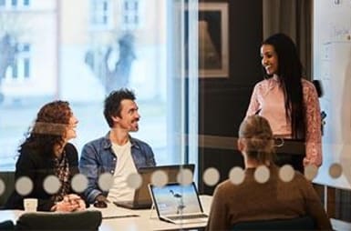 Four people in a meeting room.