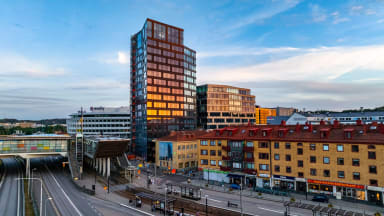 A cyclist moving along a street with newly built houses surrounding it.