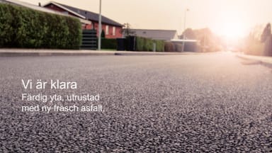 Bilden visar en gata i ett bostadsområde med låga hus och gröna häckar. Bilden domineras av asfalten. Texten i bilden lyder: Vi är klara. Färdig yta, utrustad med ny fräsch asfalt.