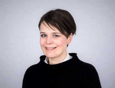 Porträtt på Nilla Olsson, teknisk doktor NCC, mot en grå bakgrund.