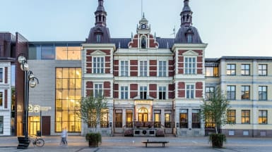 Rådhuset i Kristianstad. En ståtlig byggnad med rödvit fasad, och två torn som sticker upp på vardera sida.