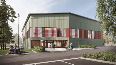 Bild på Hertsö Badhus i Luleå, grönt hus omringat av träd.