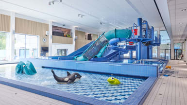 Simanläggning med barnpool och rutschkana.