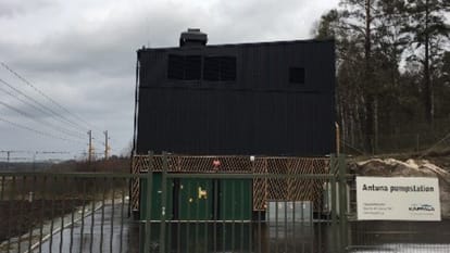 Solgryningen lyser upp Antuna pumpstation och en bil intill, samt naturen i bakgrunden.