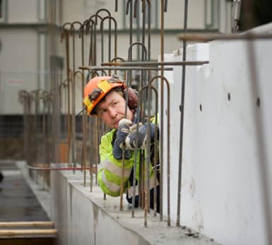 En arbetare justerar armeringen för betong.