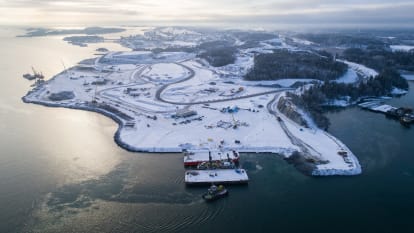 Illustration of the new Norvik logistics hub. Visible is a large harbor with several boats and containers, with the city of Nynäshamn in the background.