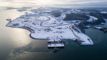 Illustration of the new Norvik logistics hub. Visible is a large harbor with several boats and containers, with the city of Nynäshamn in the background.