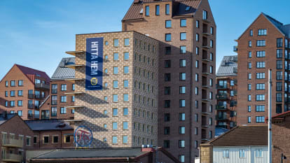 Flera gula och röda höghus med blå himmel i bakgrunden.