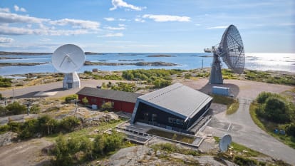 Onsala rymdstation vid vattnet, omgivet av grönska.