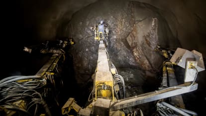 A worker does some work on a tunnel wall with the help of machinery.