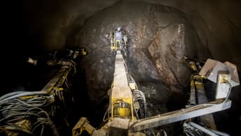 A worker does some work on a tunnel wall with the help of machinery.