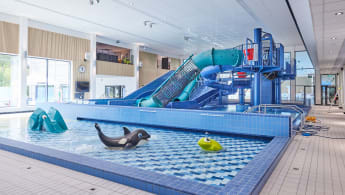 Simanläggning med barnpool och rutschkana.