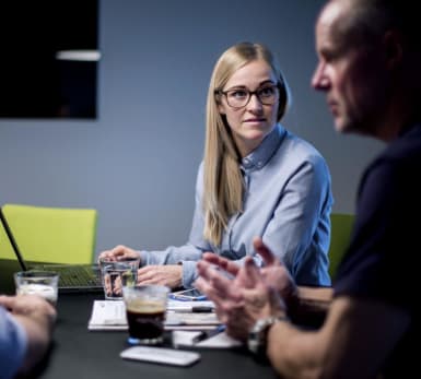 Picture of three people having a serious discussion in a room.