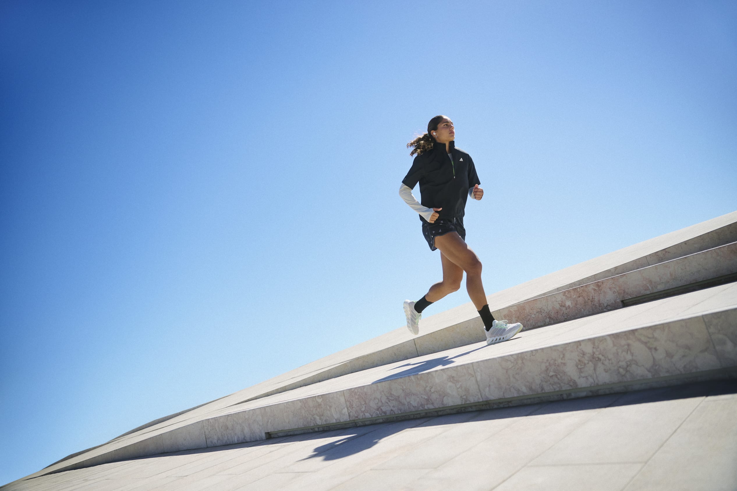 A person running in adidas gear on the open city