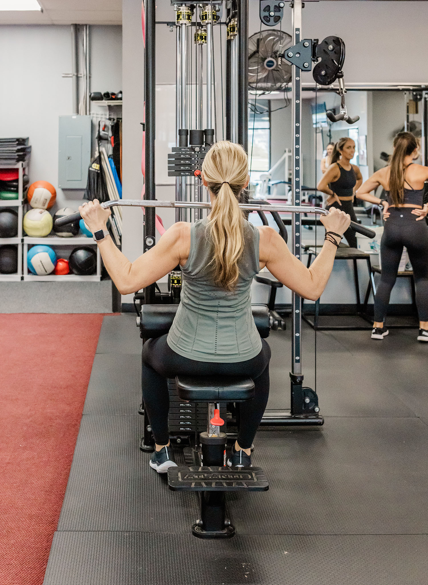 Michelle works out using the lat pull down machine.