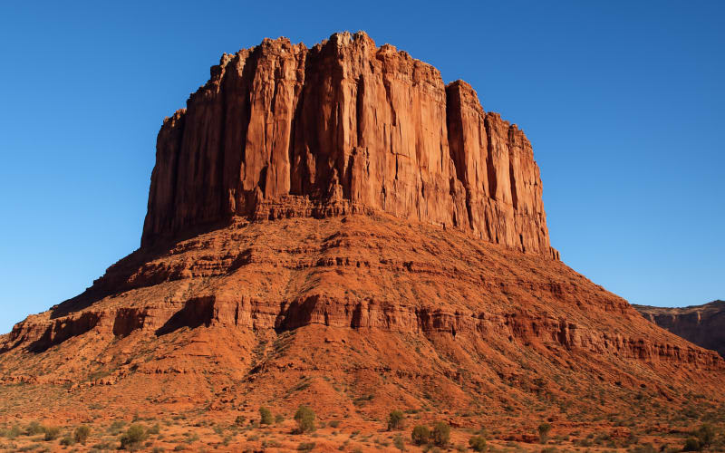 A breathtaking view of Troll Wall in Utah, featuring rugged cliffs and clear blue skies.