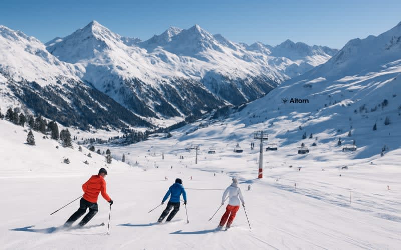 A picturesque view of St. Anton ski resort in Austria with snow-covered mountains and skiers descending the slopes.