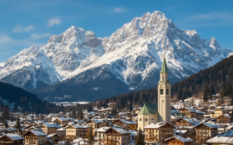 A picturesque view of Cortina d'Ampezzo with its snow-capped peaks and charming village below.