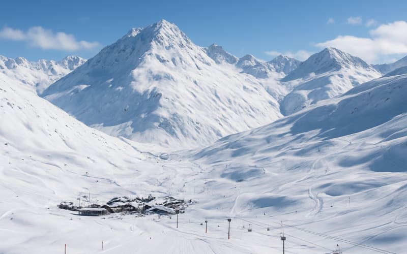 A breathtaking view of the Andermatt ski resort with snow-covered mountains and ski trails.