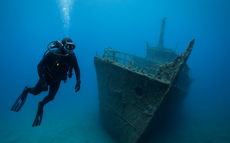 A scuba diver exploring a shipwreck in Thunder Bay, surrounded by clear blue waters.
