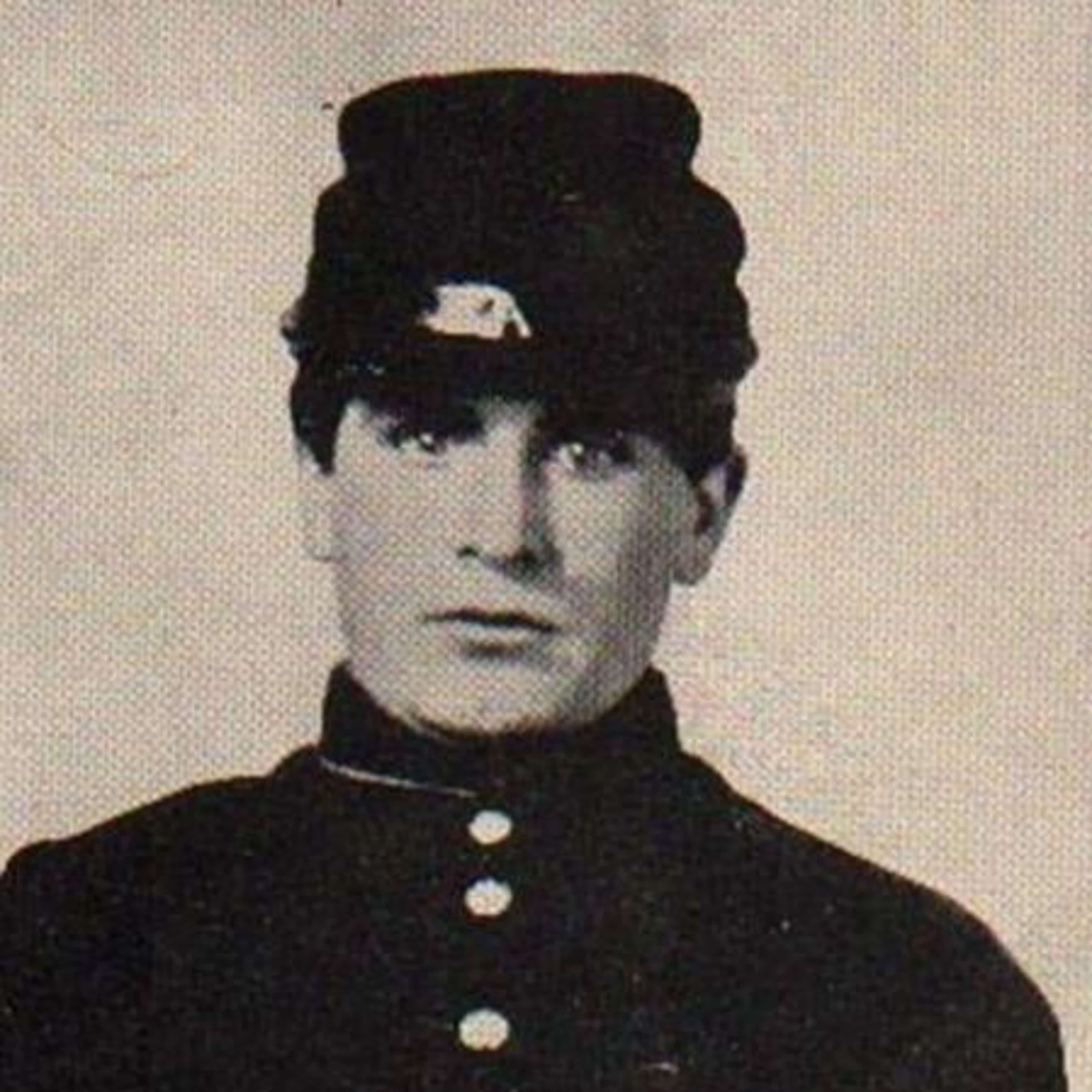 A black and white portrait photograph of a man wearing a military uniform with a cap, his face and upper body visible against a plain background.