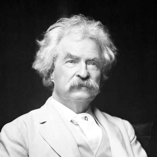Mark Twain (Samuel Clemens) 1885-1910, lecturer and author of great literature. In this 3/4 length photograph he's seated holding a cigar, in a white suit. Undated.