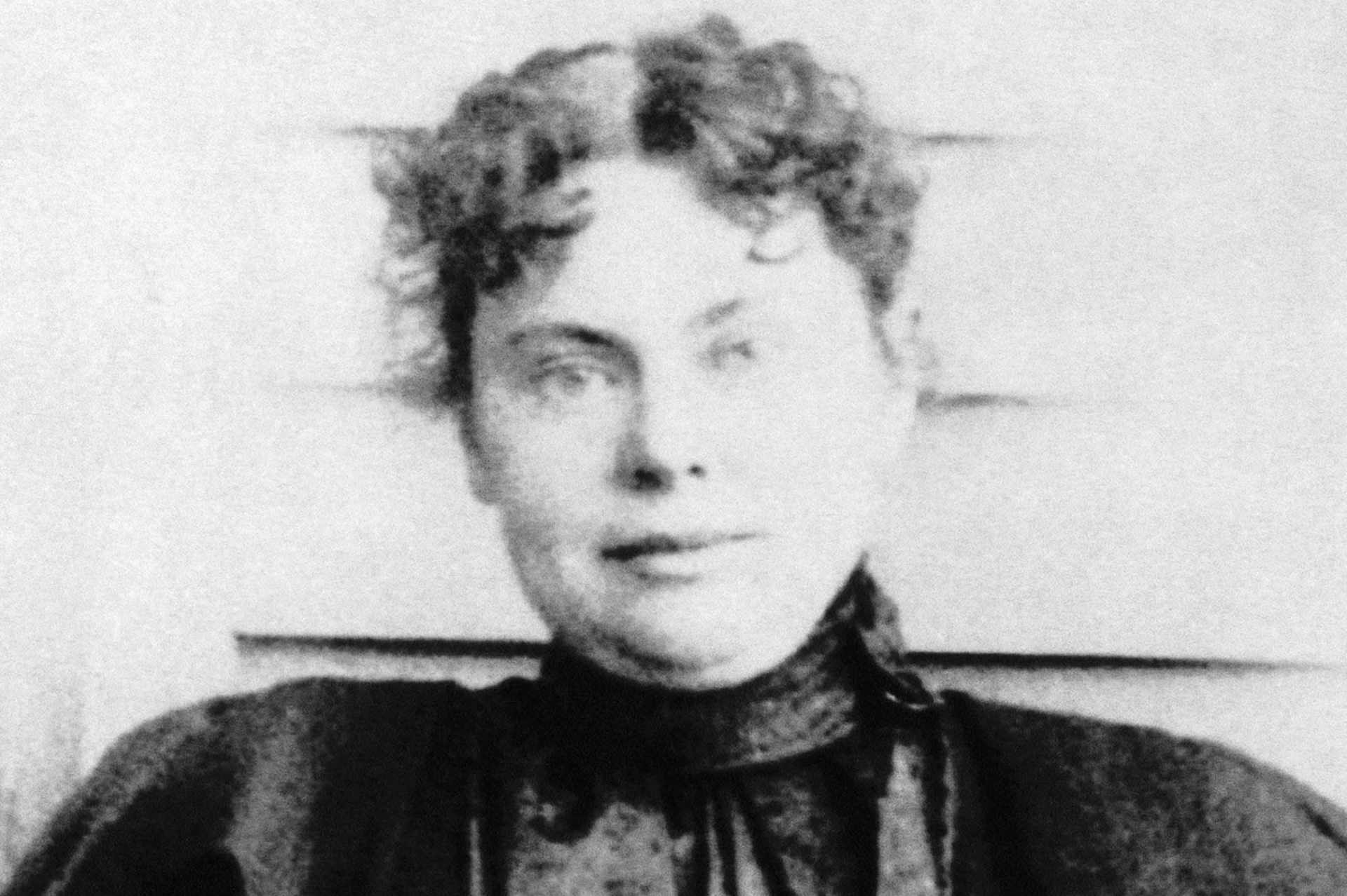 A black and white portrait of a person with a pensive expression, set against a blurred background.