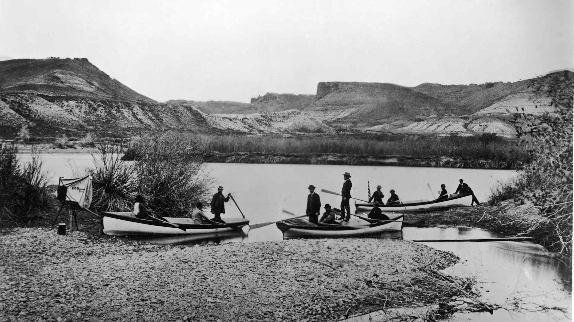 Men in small boats on a river in the wilderness