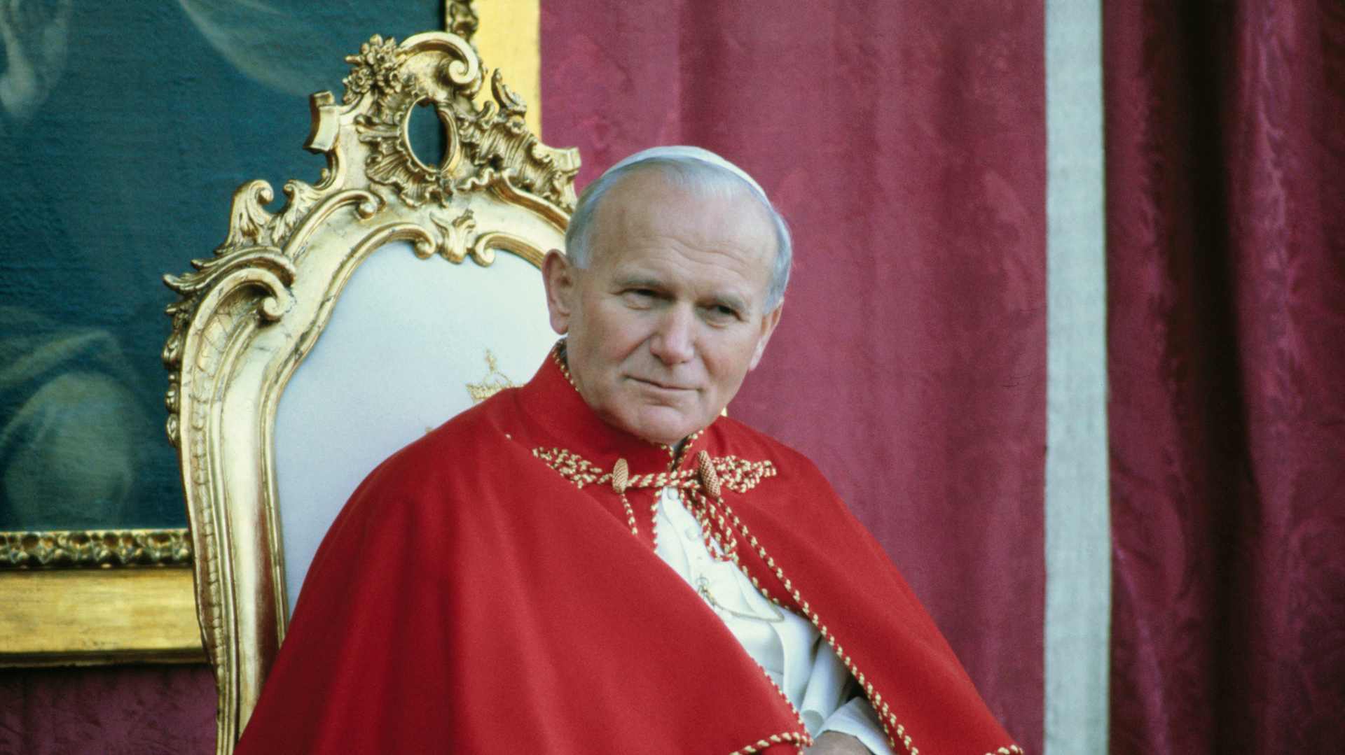 Pope John Paul II, shown sitting on a chair, during a 1982 visit to Avila, Spain.