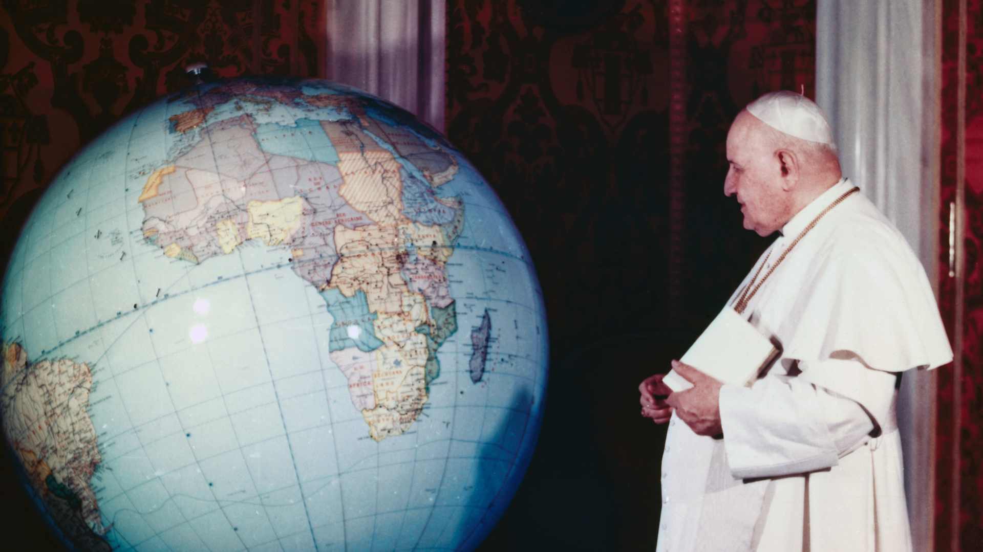 Pope John XXIII in his papal apartment at Vatican City, looking at huge globe of the world.