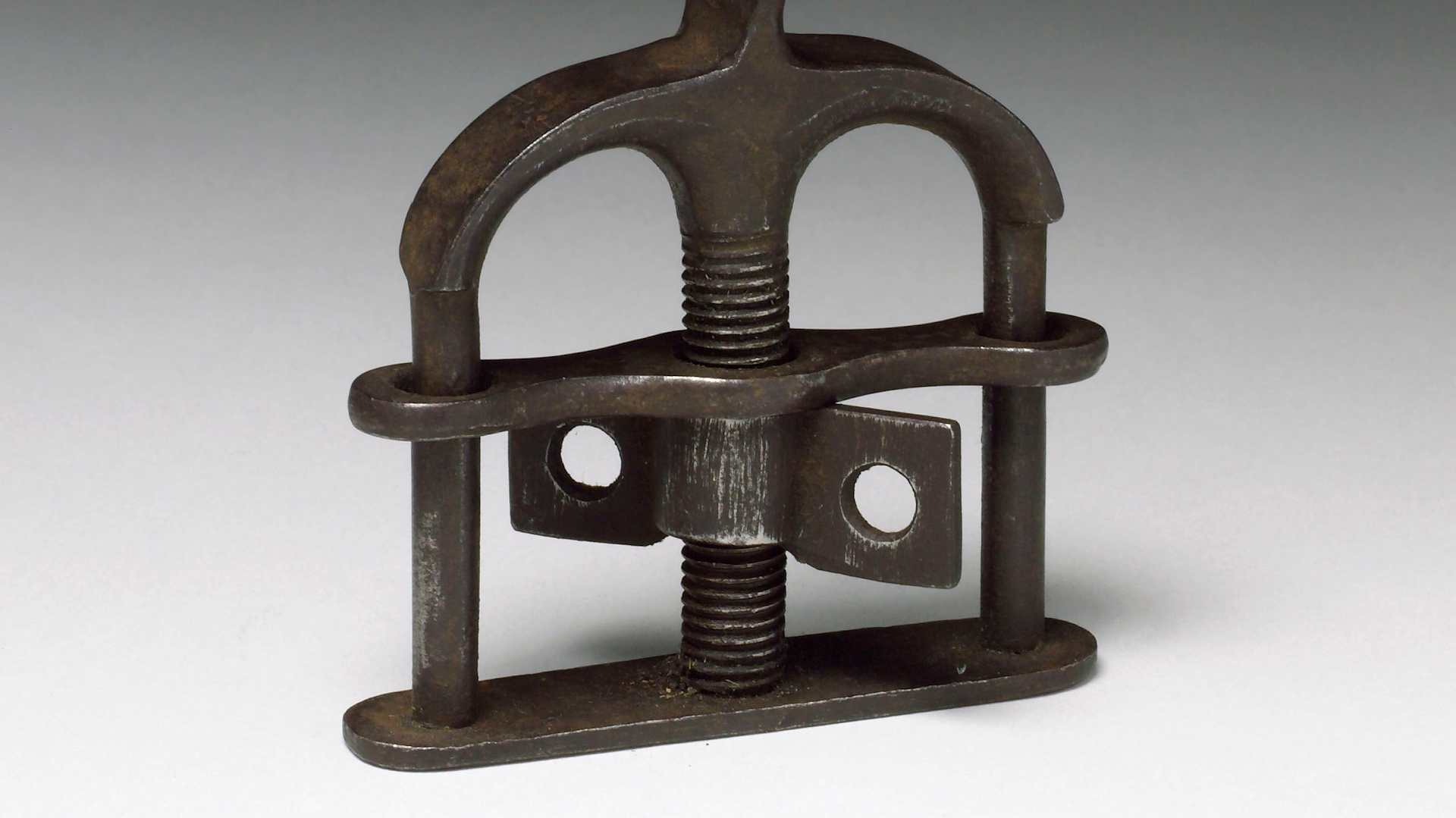 A steel torture contraption with a giant screw in the middle.
