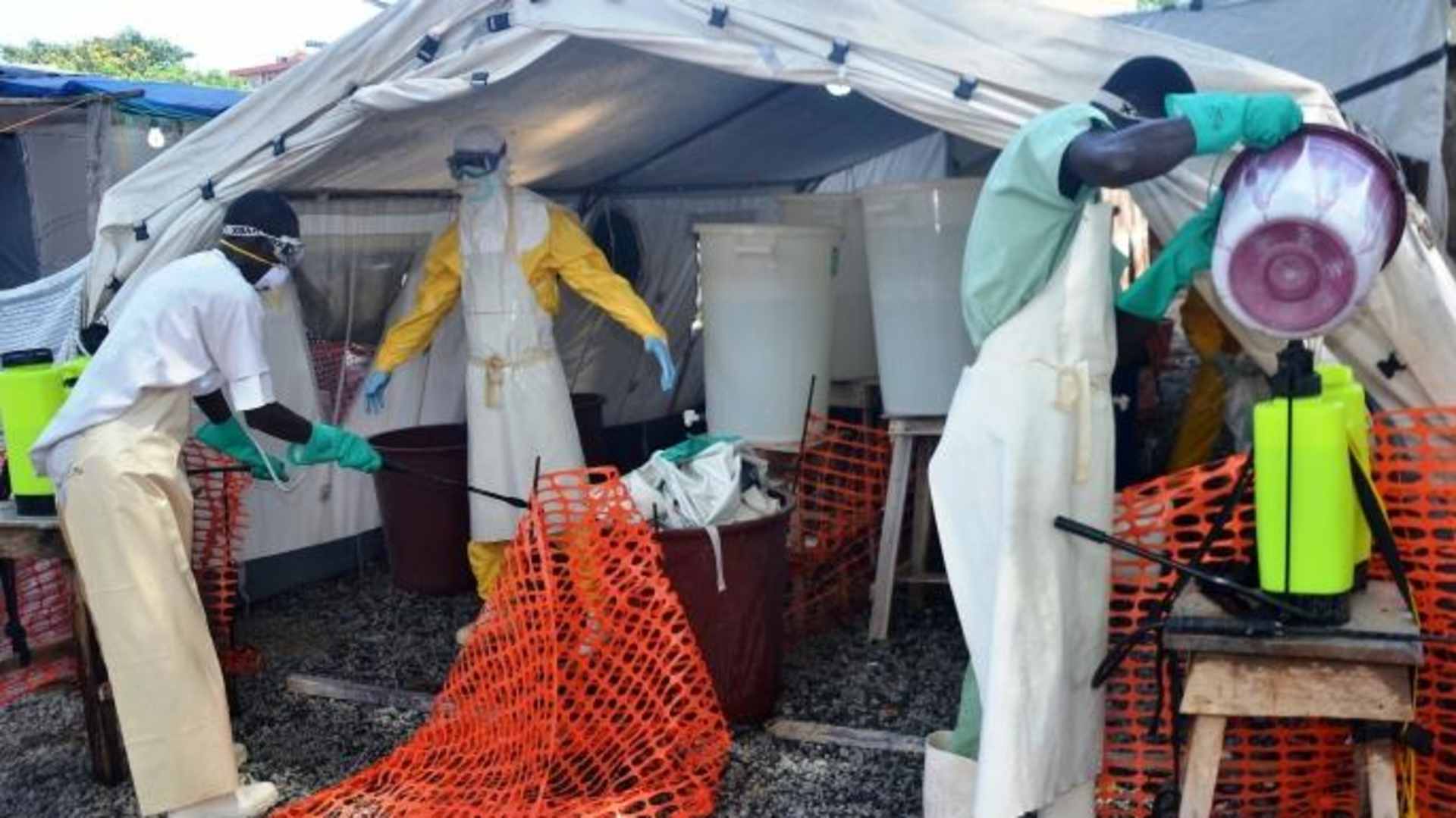 A health worker wearing a protective suit is sprayed down as he joins members of the Medecins sans frontieres Ebola treatment center. (Credit: Cellou Binani/Getty Images)