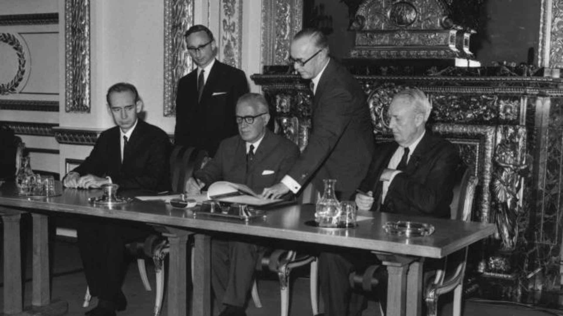 Britain's Foreign Secretary Michael Stewart signs the treaty on the Non-Proliferation of Nuclear Weapons at Lancaster House, London, watched by the Soviet Ambassador (L) and the US Ambassador (R), July 1 1968.  (Credit: Jim Gray/Keystone/Getty Images)