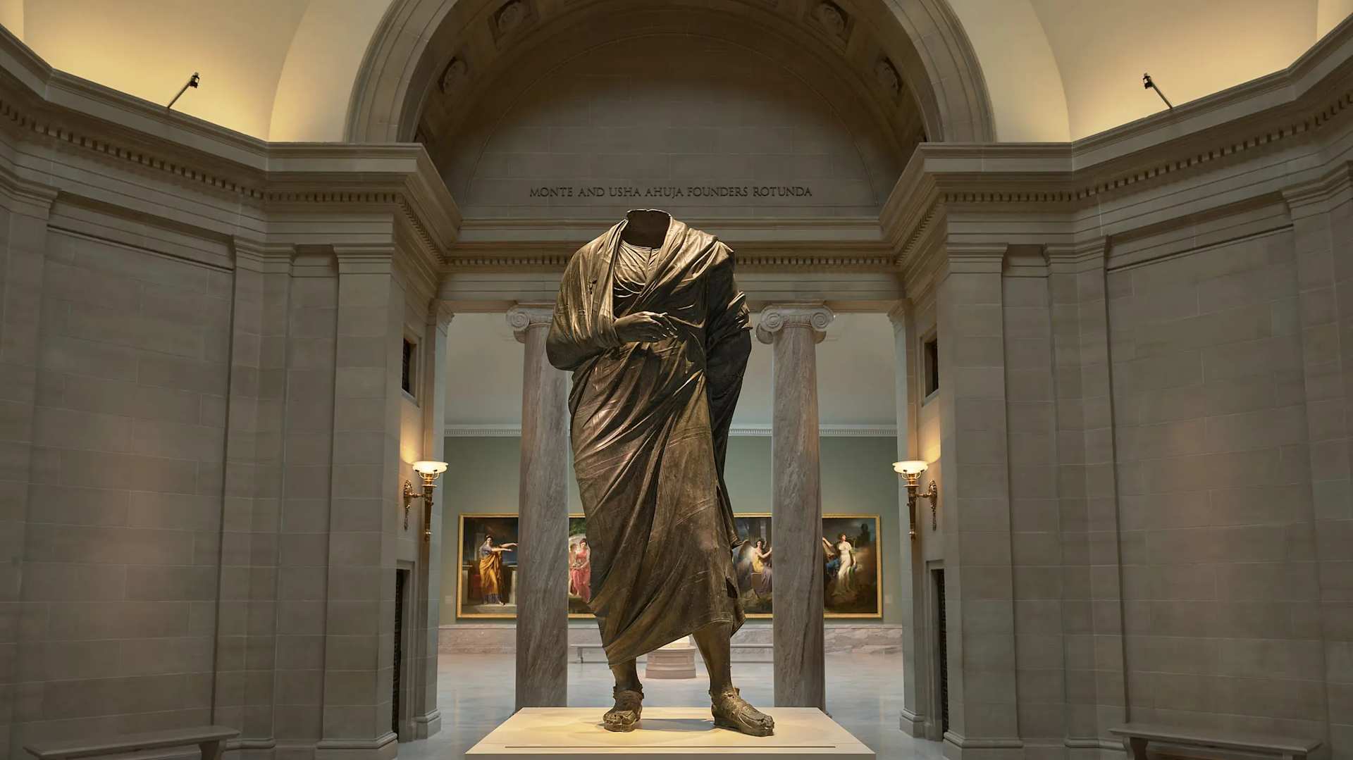 Ancient Greco-Roman bronze statue of a standing draped male figure.