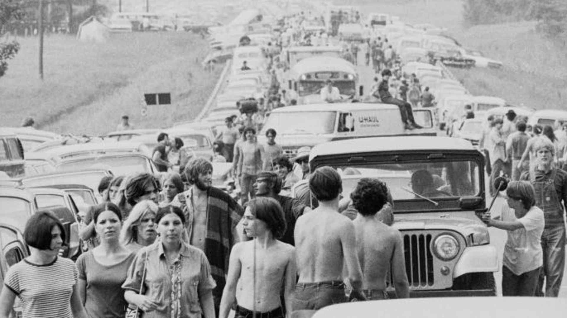 Crowds walk along roads choked with traffic on the way to Woodstock. (Credit: Hulton Archive/Getty Images)
