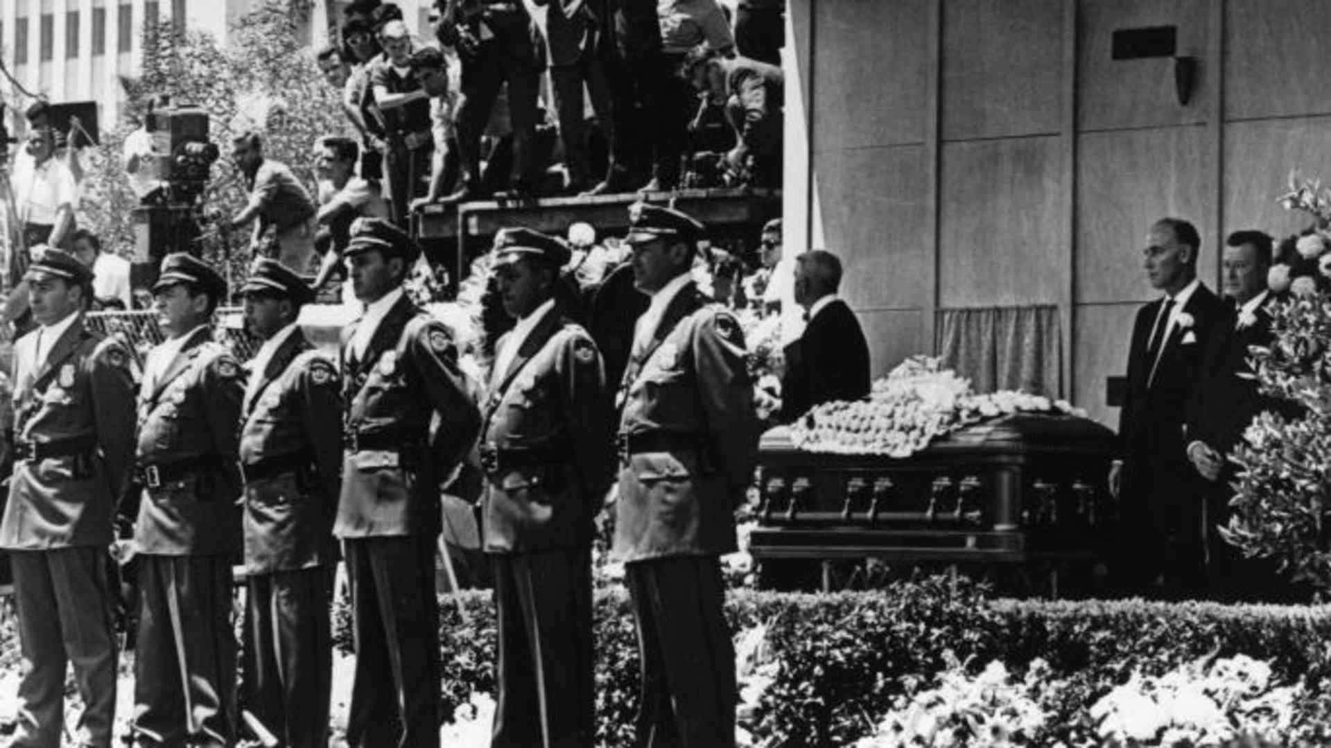 Detectives from the Pinkerton Agency guard the coffin of  Marilyn Monroe at her funeral in Westwood Memorial Park, in August 1962.  (Credit: Keystone/Getty Images)