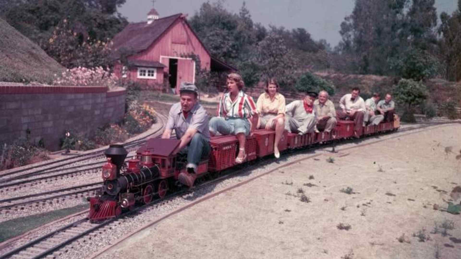 Disney drives a miniature railroad filled with passengers at his California home. (Credit: Gene Lester/Archive Photos/Getty Images)