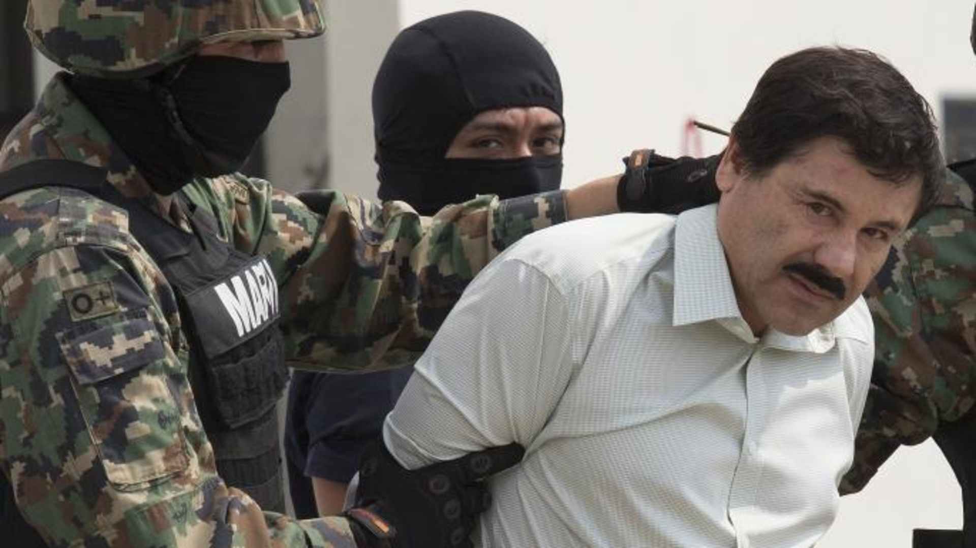 Drug trafficker Joaquin "El Chapo" Guzman is escorted to a helicopter by Mexican security forces. (Credit: Susana Gonzalez/Getty Images)