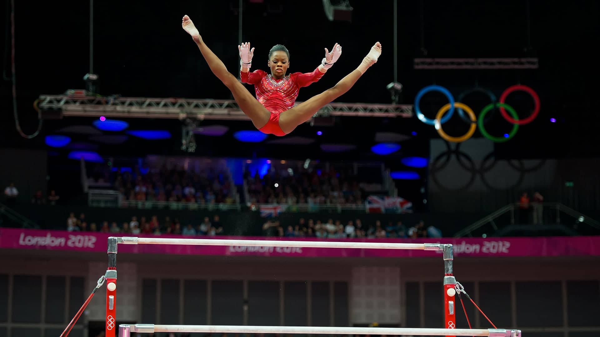 Gabrielle Douglas of the United States soared over the uneven bars apparatus during women's team gymnastics finals at North Greenwich Arena during the 2012 Summer Olympic Games in London, England, Tuesday, July 31, 2012.