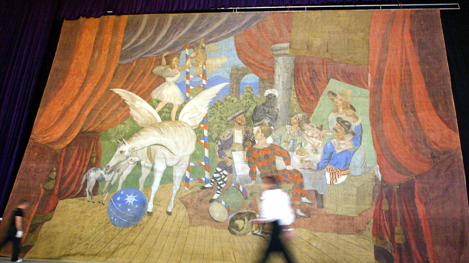 A man walks past one of Pablo Picasso's most famous work, the monumental stage curtain for the realist ballet "Parade" at an Atrium in Hong Kong, 11 October 2004.
