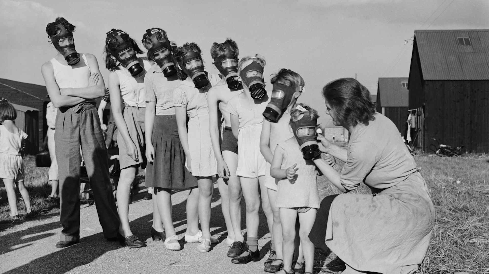 Farm children have their gas masks checked during a World War II-era drill.