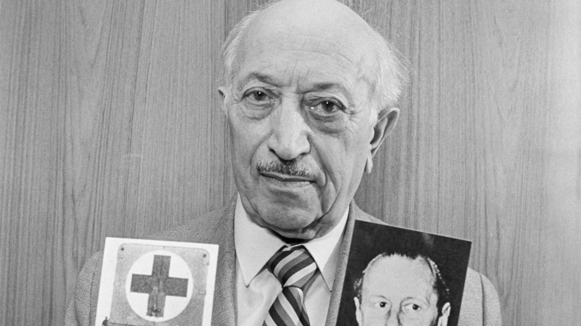 Nazi hunter Simon Wiesenthal holding photographs depicting former Gestapo chief Walter Rauff and a mobile gas-chamber van he created to execute Jews. Rauff was protected from prosecution by Chilean president Augusto Pinochet.