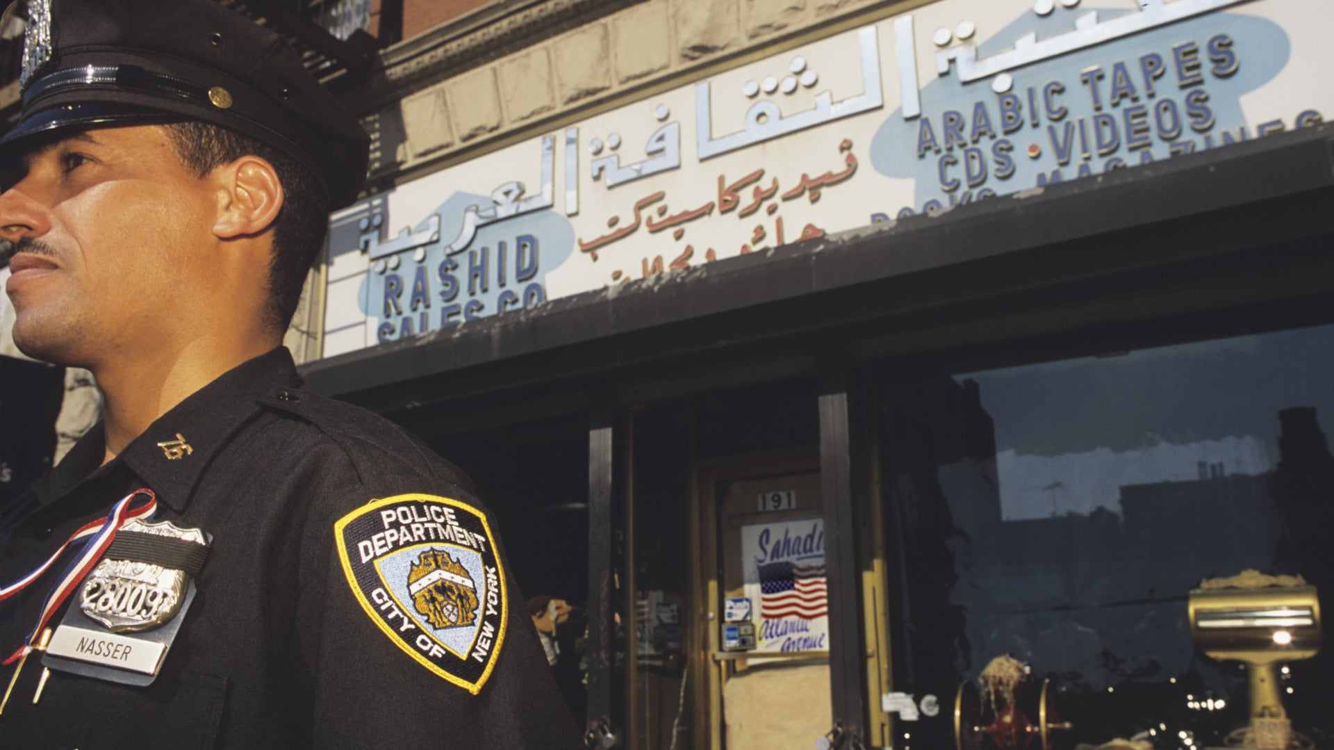 NYPD officer guarding stores of the Arab community to protect against displaced hostility in the wake of 9/11