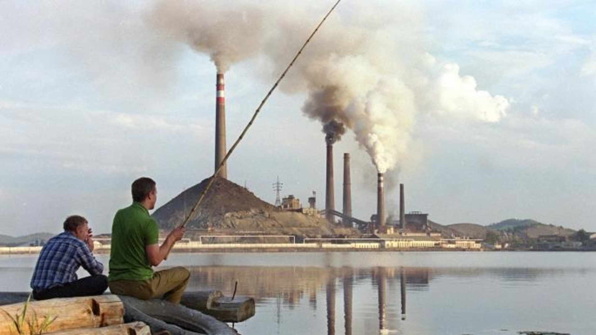 Two local men try to catch some fish in a lake next to Karabash copper smelting plant. (Credit Alexander Nemenov/Getty Images)