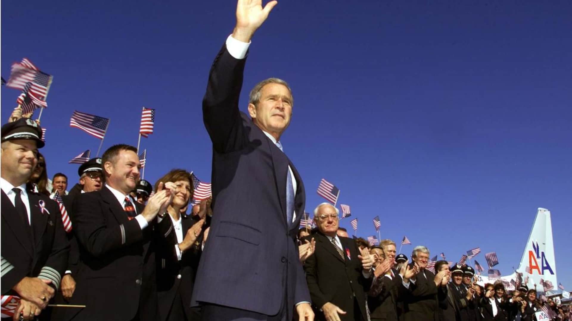 US President George W. Bush waving to thousands of airline employees before his speech to announce expanded US aviation security procedures which include more Air Marshals, aircraft cockpit modifications and new standards for ground security operations at Chicago's O'Hare International Airport. (Credit: Paul J. Richards/AFP/Getty Images)