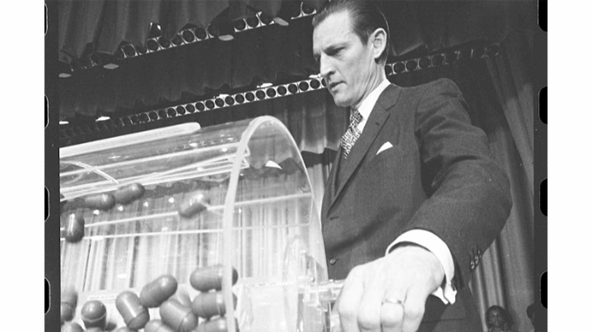 Curtis W. Tarr, spinning a draft lottery drum, led the Selective Service System from 1970 to 1972.