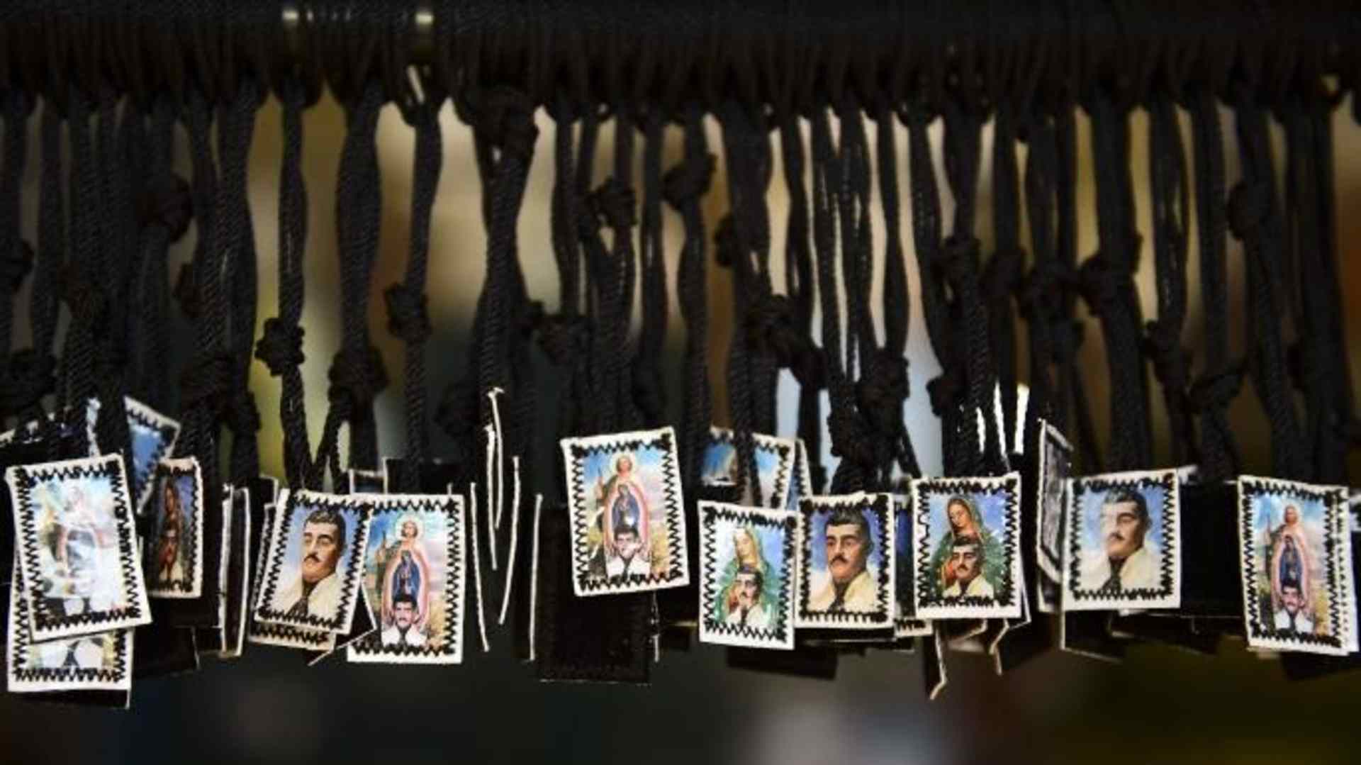 View of scapulars depicting Jesus Malverde, who according to legend was a Robin Hood-type bandit who stole from the rich and gave to the poor. (Credit: RONALDO SCHEMIDT/AFP/Getty Images)