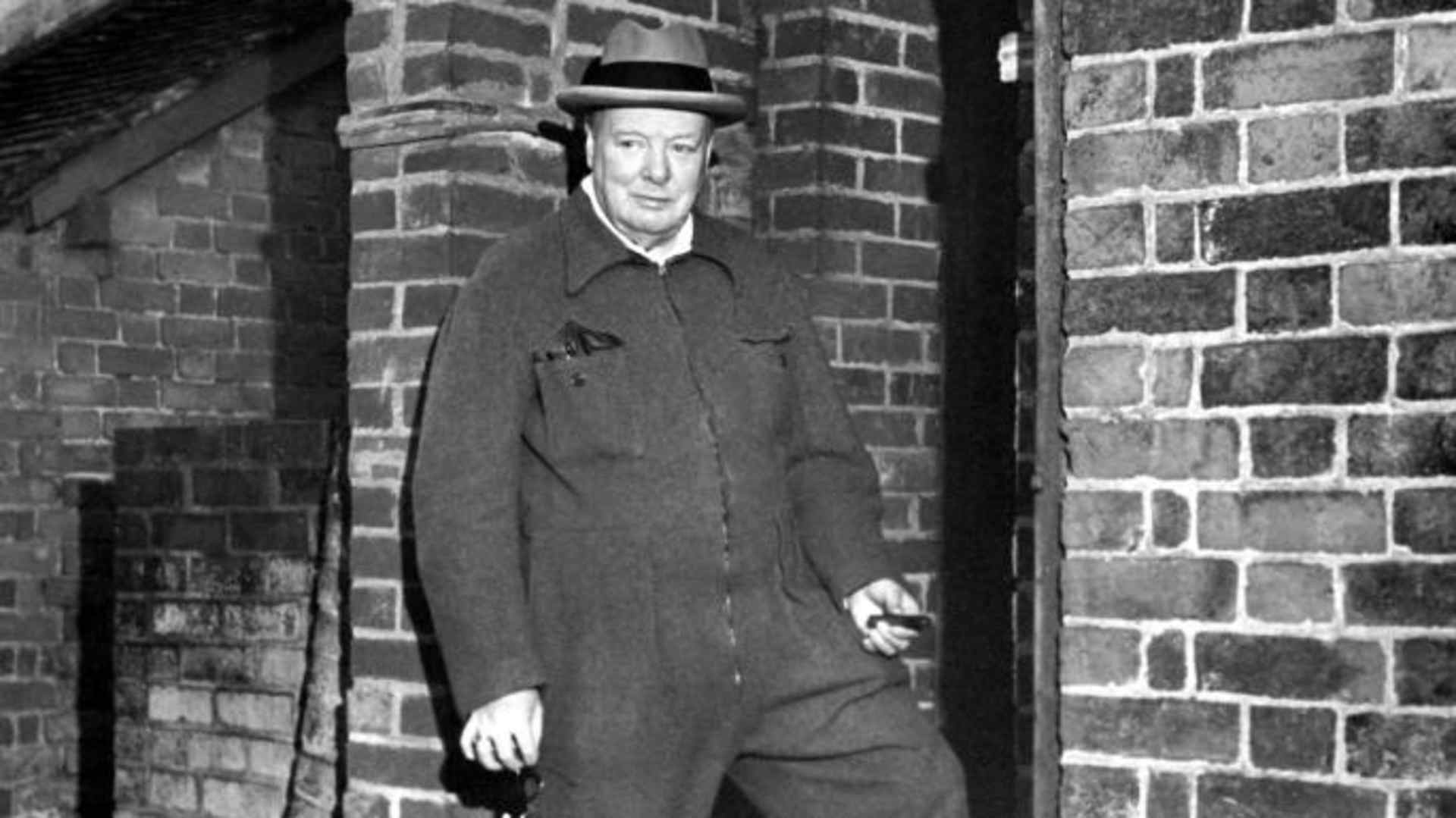 Winston Churchill relaxing in a siren suit smoking a cigar. (Credit: Jeremy Moeran / Alamy Stock Photo)