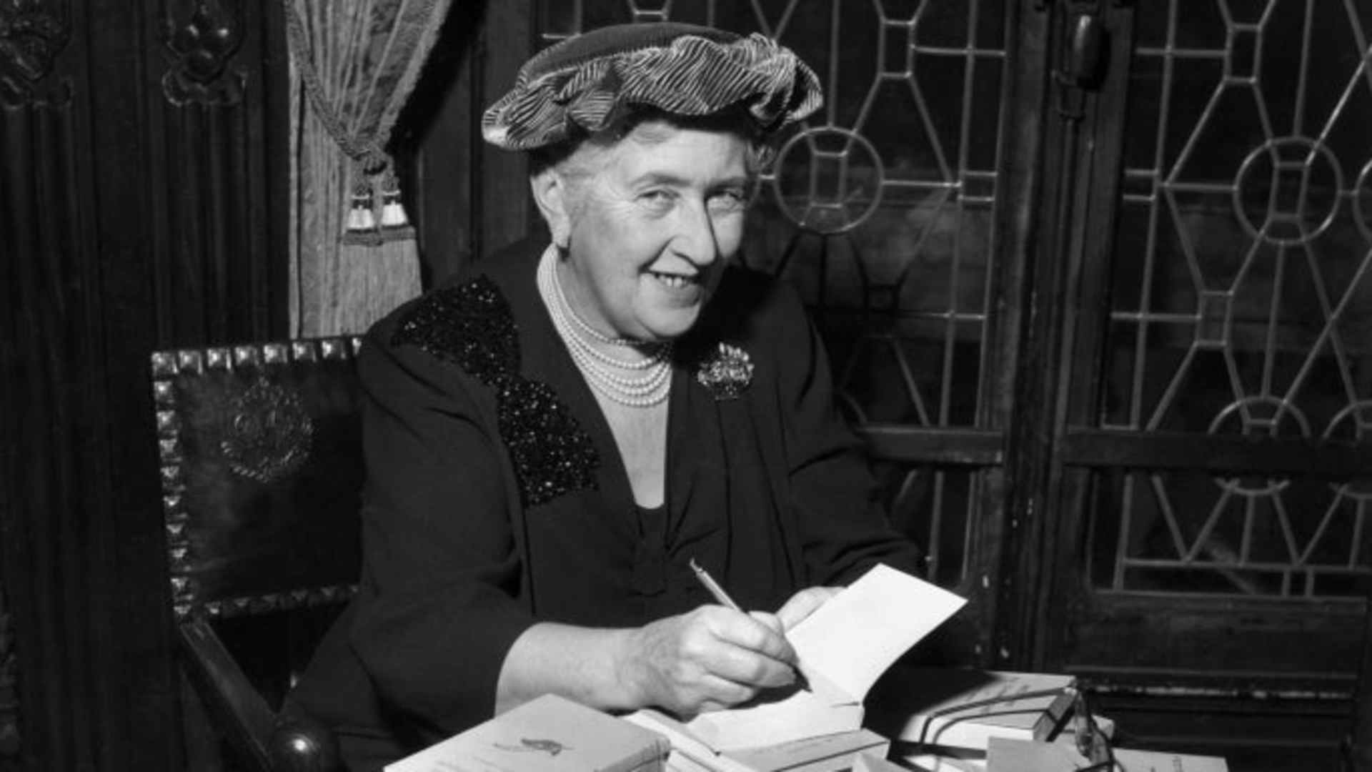 British mystery author Agatha Christie autographing French editions of her books.