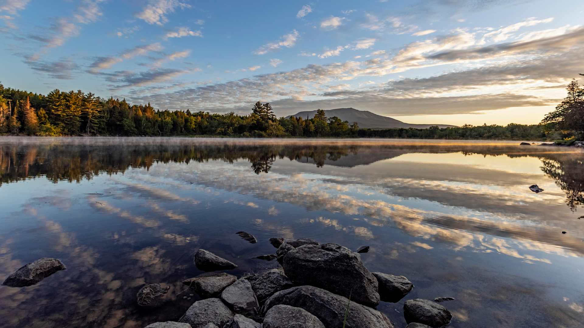 Sunrise over still calm Penobscot River, Katahdin in distance, Maine